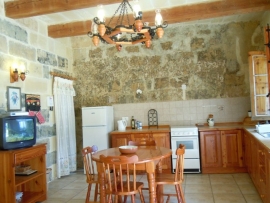 GUNO holiday house kitchen and dining area with multilingual channels on television